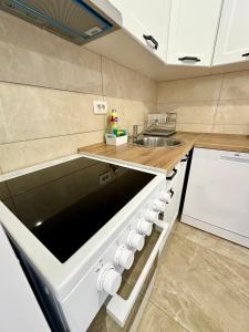 a kitchen with white cabinets and a sink and a stove at Montenegrina Apartment in Budva