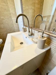 a bathroom with a sink and two faucets at Montenegrina Apartment in Budva