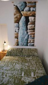 a bedroom with a bed with a painting on the wall at The Studio in Orkney