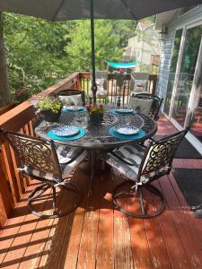 un tavolo da patio con sedie e ombrellone su una terrazza di Majestic Lake Front Chalet a Tobyhanna