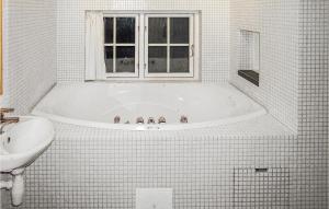 a white bathroom with a tub and a sink at Holiday Home Gålå Peer Gyntlia in Gålå