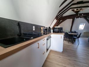 eine Küche mit Spüle und einem Tisch mit Stühlen in der Unterkunft L'échappée moderne in Chinon