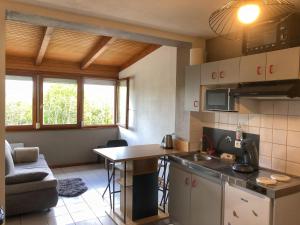 a kitchen and living room with a table and a couch at Charton au Markstein in Oderen