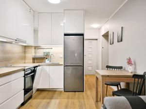 a kitchen with white cabinets and a wooden table at CLASSY APARTMENTS - AQUAPARK Reda III in Rumia +11 photos