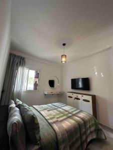 a bedroom with a bed and a television in it at Appartement bella vista in Cabo Negro +13 photos