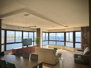 a living room with a couch and a table with a television at Sea View Luxury Haven Living & 3Bedrooms Seafront in Sliema