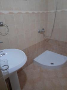 a bathroom with a white sink and a toilet at Tina's Apartment in Gjirokast&euml;r