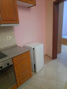 a kitchen with a white refrigerator and a stove at Tina's Apartment in Gjirokastër +3 photos