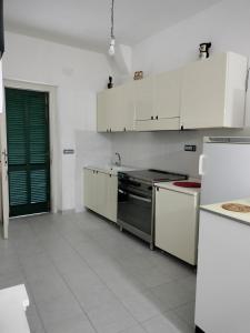 a kitchen with white cabinets and a stove top oven at Sunny House in Parghelia +27 photos