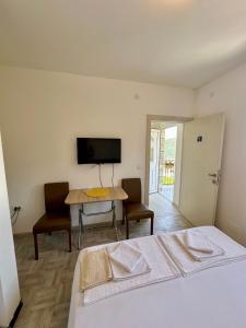 a bedroom with a bed and a table and a television at Montenegrina Apartment in Budva +37 photos