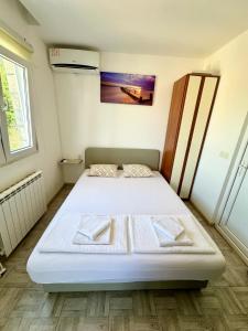 a bedroom with a white bed in a room at Montenegrina Apartment in Budva