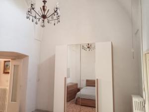 una camera da letto con specchio e lampadario pendente di Dimora storica Principi di Savoia a Lecce