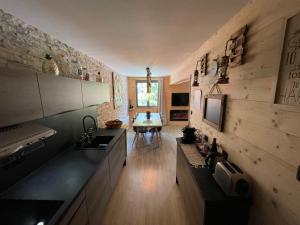 a kitchen with a sink and a table in a room at Appartement style chalet T4 in Uvernet