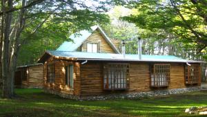 a log cabin in the woods with trees at La Casa Escondida in Punta Arenas