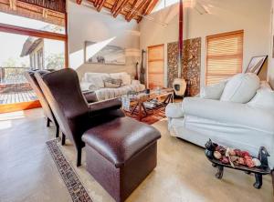 a living room with a leather chair and a couch at Des'lgodini Lodge - PRM078 in Bela-Bela +25 photos