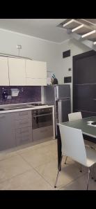 a kitchen with a table and white chairs in it at Residence Hotel Le Viole in Rimini