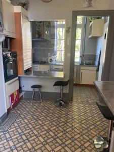 a kitchen with a counter and two stools in it at Chez Gigi in Huchenneville