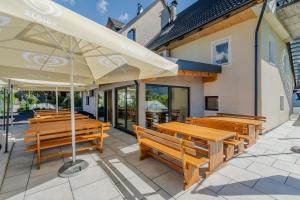 a group of wooden benches and umbrellas on a patio at Penzion Hosnar, apartma Time Out in Bovec