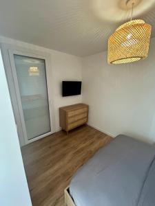 a bedroom with a bed and a window and a television at Appartement moderne in Cap d'Agde