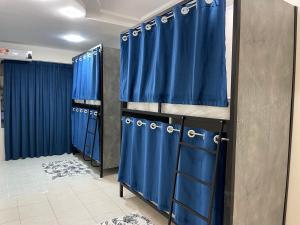 a row of blue curtains in a dressing room at Asia Hostel in Tashkent