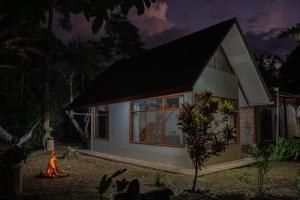 una pequeña casa con un fuego delante de ella en Magico Bosque - Bungalow, en Moyobamba 23 fotos más