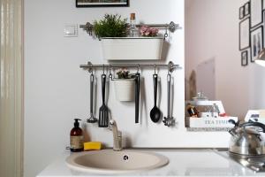 a kitchen sink with utensils hanging on a wall at Historic 5 star apartment in the main plaza in Cluj-Napoca +33 photos