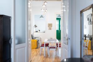 a living room with a white table and yellow chairs at Historic 5 star apartment in the main plaza in Cluj-Napoca