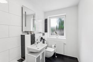 un bagno bianco con lavandino e WC di Komfort Apartment Küche Balkon 3 Zi a Geesthacht Altre 18 foto