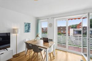 una sala da pranzo con tavolo, sedie e una finestra di Komfort Apartment Küche Balkon 3 Zi a Geesthacht