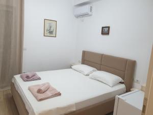a bedroom with a bed with two towels on it at Rooms by George in Dhërmi