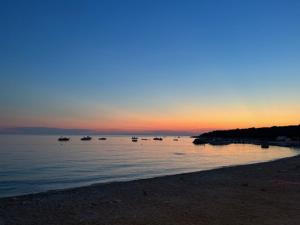 a beach with boats in the water at sunset at SeaFun Apartment Gajac in Gajac