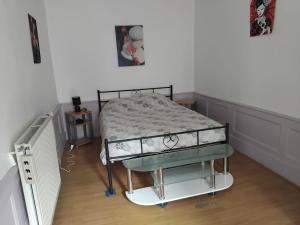 a bed in a room with a bed frame at Appartement F3 centre de Mirecourt in Mirecourt +4 photos