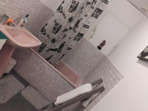 a bathroom with a pink tub and a sink at Appartement F3 centre de Mirecourt in Mirecourt