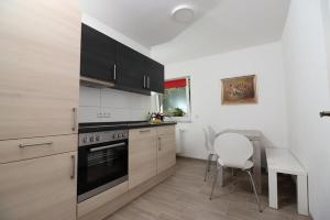 a kitchen with a stove and a table with chairs at Ferienwohnung Waldhauser in Breitenberg