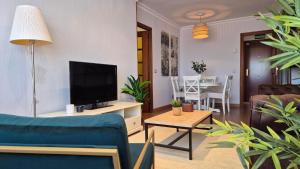 a living room with a couch and a tv at El Espolón de Valdenoja in Santander