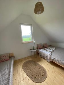 a attic room with two beds and a rug at Zakątek Pierszczewo Kaszuby in Pierszczewko