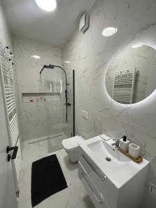 a bathroom with a sink and a toilet and a mirror at Novostavba v centre + parking in Banská Bystrica