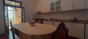 a kitchen with a table with a bowl of fruit on it at Roof Terrace Apartment in Historical Centre in Tavira
