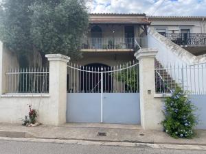 a house with a white gate and a fence at Maison avec superbe terrasse tropézienne in Adissan