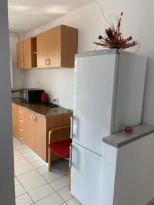 Una cocina con refrigerador blanco y gabinetes de madera. en Good luck apartament, en Mediaş