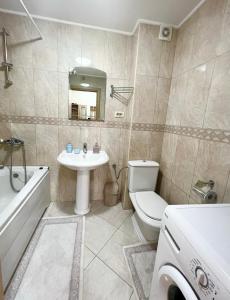 a bathroom with a toilet and a sink and a tub at Apartments Nirgilija in Tivat