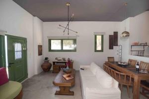 a living room with a white couch and a table at Korasida View Apartment in Akhladherí +43 photos
