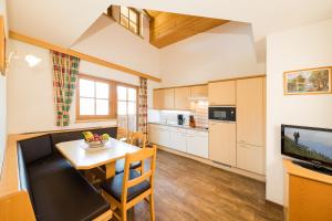 a kitchen with a table and a dining room at Feriengut Hasenau in Saalbach-Hinterglemm