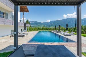 a villa with a swimming pool and mountains in the background at Ferienwohnungen Zwerger Reinhold in Termeno +66 photos