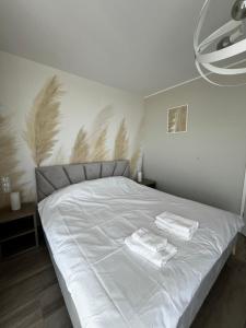 una camera da letto con un letto con due asciugamani sopra di Apartament w Baltic Cliff a Niechorze Altre 15 foto