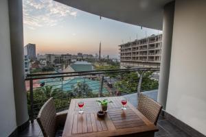 a table with two glasses of wine on a balcony at 2 Sleeper with King Bed at Point Waterfront in Durban