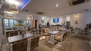 a restaurant with tables and chairs and a counter at Metsikas Residence in Limenas