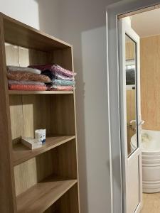 ein Zimmer mit einem Kleiderschrank mit Holzregalen und einem Spiegel in der Unterkunft Vila Baciu in Tuzla + 95 Fotos