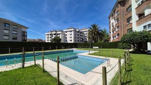 a swimming pool in front of some buildings at El Espolón de Valdenoja in Santander