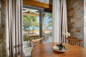 a dining room with a table and a large window at Brothers Studios & Suites in Skala Potamias